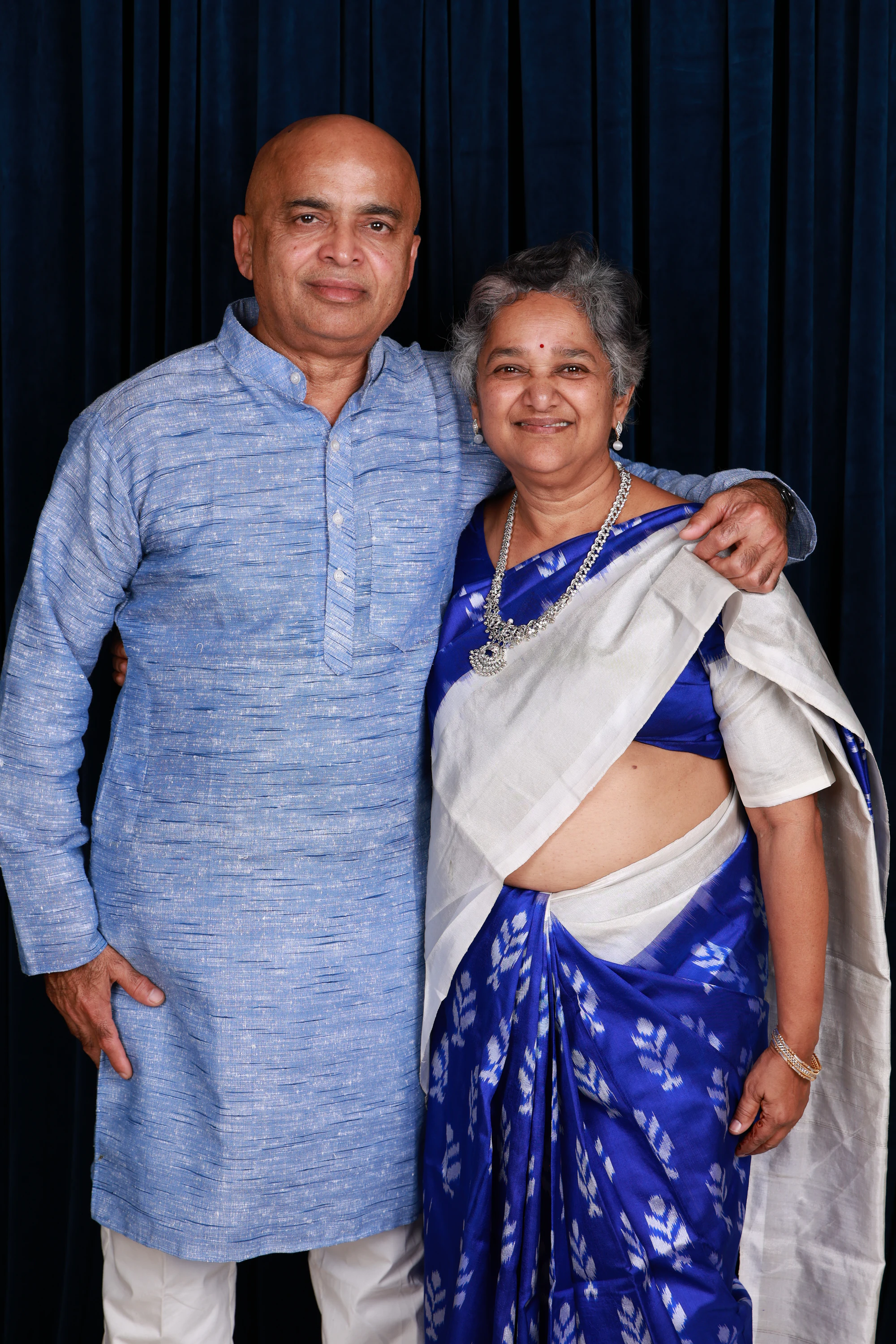 An older couple in a blue kurta and blue sari at Ramya + Sreehari's wedding